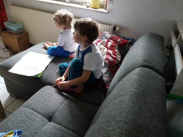 zwei kleine Jungs sitzen auf dem Sofa und fernsehen.